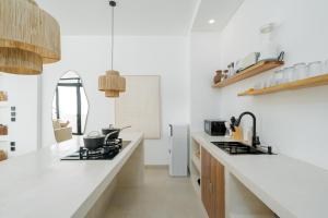 a kitchen with white walls and a counter top at Casa Agapi in Tumbak Bayuh