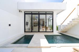 a swimming pool in front of a house with a staircase at Casa Agapi in Tumbak Bayuh