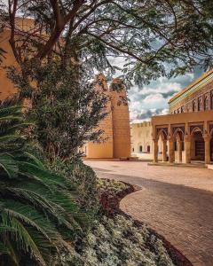un edificio con un albero di fronte a un cortile di Saraya Palace Hotel a Doha