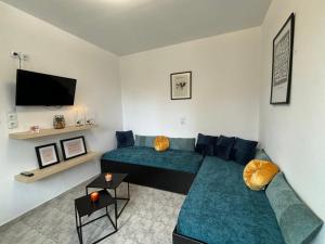 a living room with a couch and a tv at Liostasi Cottage in Kariotes