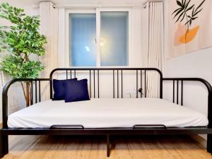 ein schwarzes Bett mit weißen Laken und blauen Kissen in der Unterkunft Cozy house in Seoul + 12 Fotos