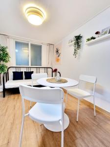 ein Wohnzimmer mit Tisch und Stühlen und einer Couch in der Unterkunft Cozy house in Seoul