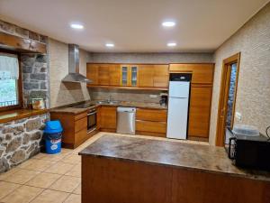 a kitchen with wooden cabinets and a white refrigerator at Casa Rural Zimitxu in Etxalar +15 photos