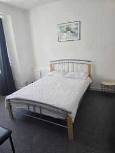 a bed in a bedroom with a picture on the wall at Simple Room Hostel style central Swansea in Swansea