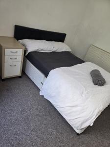 a bed in a room with a nightstand and a bed sidx sidx sidx sidx at Simple Room Hostel style central Swansea in Swansea +3 photos