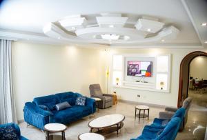 a living room with blue couches and tables at Isange Guest House in Nalakonge
