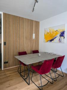 une table à manger avec des chaises rouges et un tableau dans l'établissement Ausseer AusZeit - beim Meranplatz, à Bad Aussee