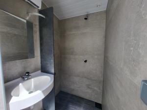 a bathroom with a white sink and a shower at Camping La Charderie in Pont-de-Labeaume
