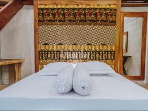 a white bed with two white towels on it at Branta Home Homestay Yogyakarta in Timuran