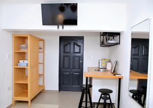 a small kitchen with a black door and a table at Petite's Nest - Studio 4 in Accra