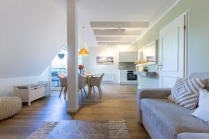 a living room and kitchen with a couch and a table at Landhaus Butt 05 in Ahrenshoop