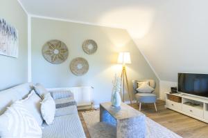 a living room with a couch and a tv at Landhaus Butt 05 in Ahrenshoop