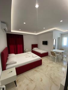 a hotel room with two beds and a table at Relax Apartments SB in Himare +16 photos