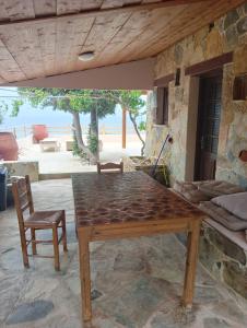 drewniany stół i krzesło w pokoju w obiekcie Elafonisi House w mieście Livadia