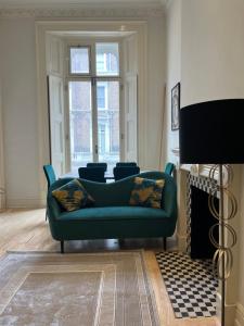 a living room with a green couch and a fireplace at Newly refurbished- Awesome very central flat in famous Notting Hill with a balcony in London