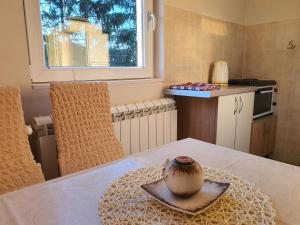 巴伊纳巴什塔Apartmani Petrovic Tara的厨房桌子上的盘子里放着一个花瓶