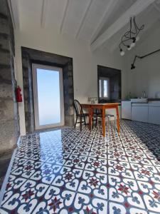 a living room with a table and a kitchen at Cá Por Casa Pico-Criptoméria in Prainha de Baixo +38 photos