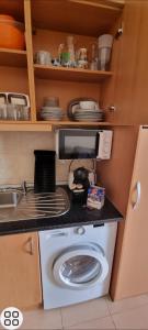 una cucina con forno a microonde e lavatrice di Praia da Rocha Flamingo Residence Summer a Portimão Altre 9 foto