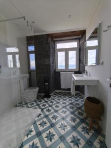 a bathroom with a sink and a tub and a toilet at Cá Por Casa Pico-Criptoméria in Prainha de Baixo