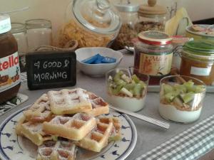 a table with waffles on a plate and jars of food at B&B Il Picchio in Mergozzo