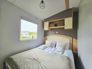 a bedroom with a bed with white sheets and a window at Hollender Pool & Chill House Sarbinowo in Sarbinowo