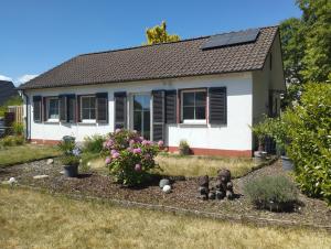a small white house with a solar roof at Ferienhaus Marion in Steinhagen