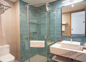 a bathroom with a toilet and a sink and a mirror at Khách sạnFlamingo Ibiza Hải Tiến in Thanh Hóa