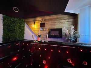 a bar with a bottle of wine and wine glasses at Love Room La Crèche Romantique in Bogny Sur Meuse