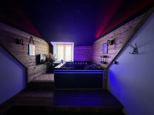 a bathroom with a large tub with purple lighting at Love Room La Crèche Romantique in Bogny Sur Meuse