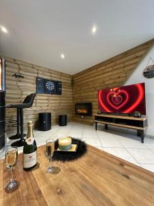 a room with a table with wine glasses and a tv at Love Room La Crèche Romantique in Bogny Sur Meuse