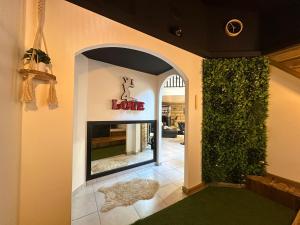 a lobby with a sign that reads love on the wall at Love Room La Crèche Romantique in Bogny Sur Meuse