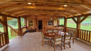 a large wooden porch with a table and chairs at Plitvice ZG in Smoljanac
