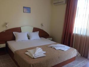 a bedroom with a bed with two towels on it at Family hotel Dramchev in Nesebar +56 photos