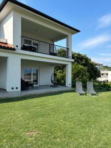a house with two chairs in a yard at Apartman Zalar in Lopar
