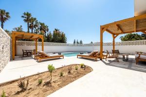 an outdoor patio with a pool and a pavilion at Casarela in Marmari