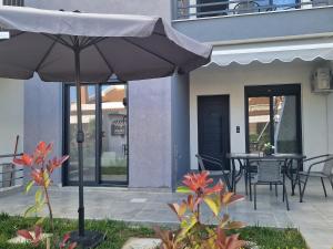 a patio with an umbrella and a table and chairs at Aelia Blu 1 in Ofrínion