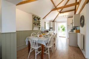 une cuisine et une salle à manger avec une table et des chaises dans l'établissement East Green Farm Cottages - The Old Stables, à Saxmundham 59 autres photos