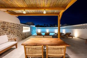 an outdoor patio with a wooden table and chairs at Casarela in Marmari