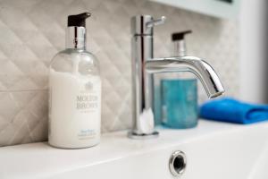 a bottle of soap sitting on a bathroom sink at The Open 2025 Accommodation in Ballycastle +34 photos