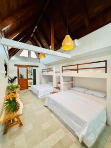 two beds in a large room with wooden ceilings at Omah Jago Sentana Yogyakarta in Timuran
