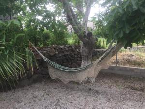 a hammock under a tree next to a pile of rocks at Hakuna Matata in Skala Eresou