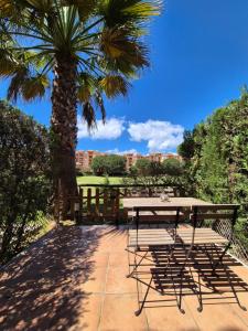 イスランティージャにあるCasa adosada en el campo de golf de Islantillaのヤシの木のあるパティオ(テーブル、椅子付) +31枚の写真