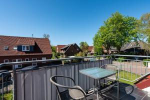 a patio with a table and chairs on a balcony at Arielle in Norddeich