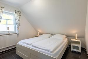 a bedroom with a bed with two lamps on it at Arielle in Norddeich