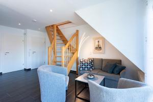a living room with a couch and a staircase at Arielle in Norddeich