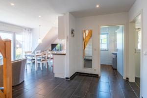 a living room with a kitchen and a dining room at Arielle in Norddeich +6 photos