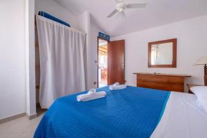 a bedroom with a blue bed with towels on it at JERA Holiday Collection VULCANO TRE - Sea View in Vulcano
