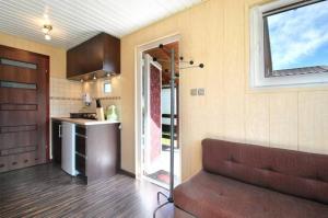 a kitchen and a living room with a couch in a room at Ośrodek Niebiańska Plaża in Sarbinowo