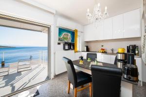 a kitchen with a table and a view of the ocean at Happy Beach Apartment - Dream on the Beach in Kraljevica