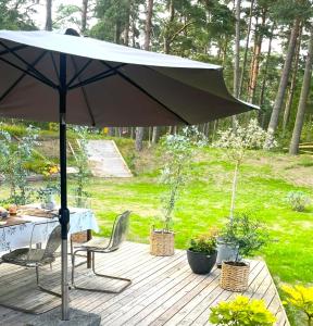 a patio with an umbrella and a table and chairs at Villa Åhus nearby The Beach in Åhus
